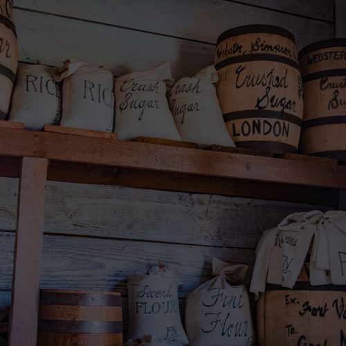 A wooden shelf with a lot of jars on it.