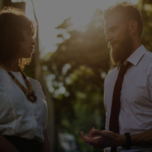 A man and woman talking in the street.