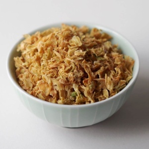 A bowl of shredded carrots in a white bowl.