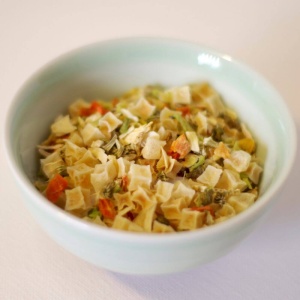 A bowl of pasta with vegetables that can be used for emergency food storage.