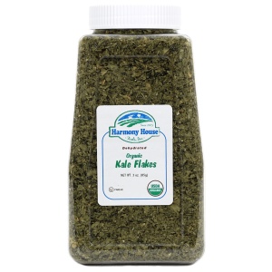 A jar of kale pesto with Harmony House Organic Dried Kale Flakes on a white background.